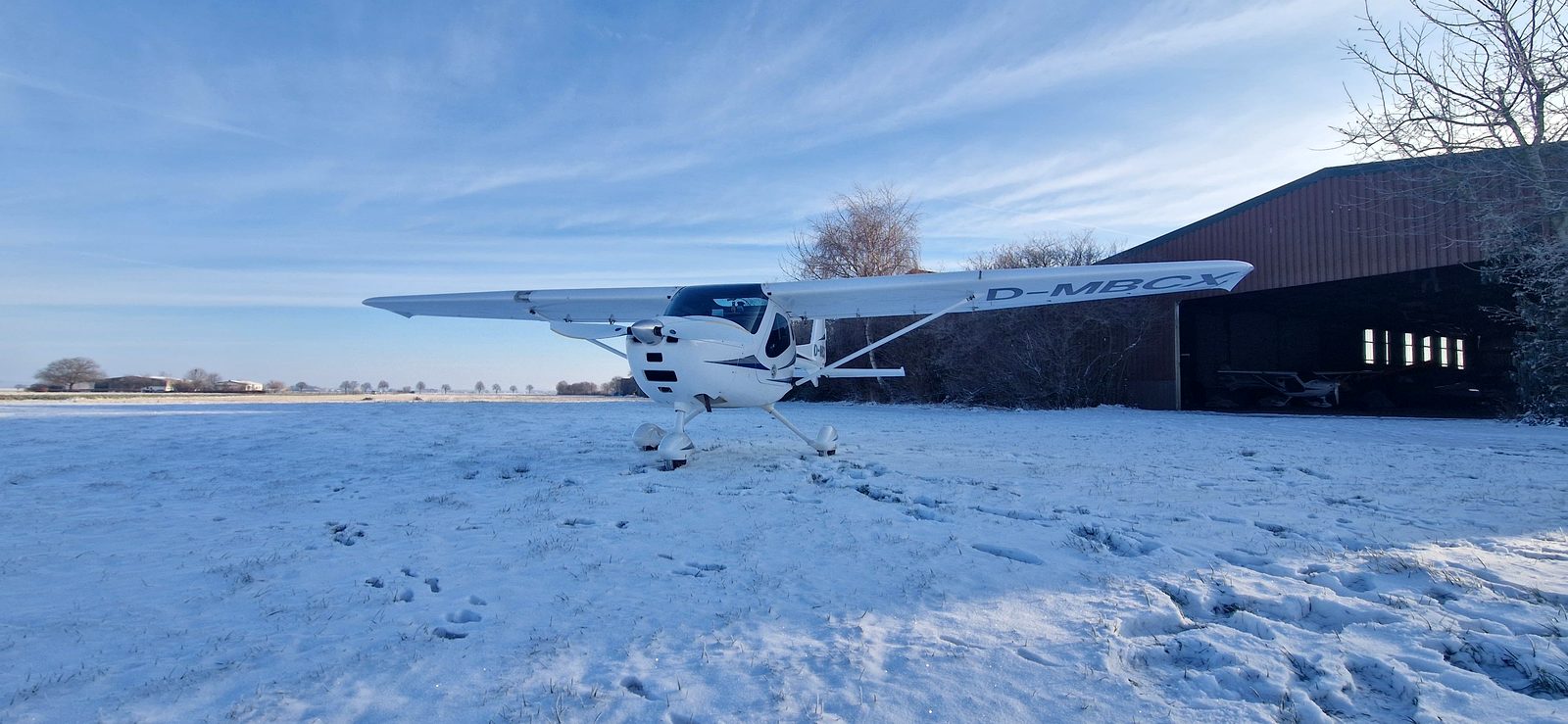 Ultraleichtflugzeug D-MBCX im Schnee vor der Halle